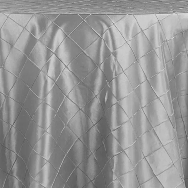 Silver pleated tablecloth on a table with a wooden surface.